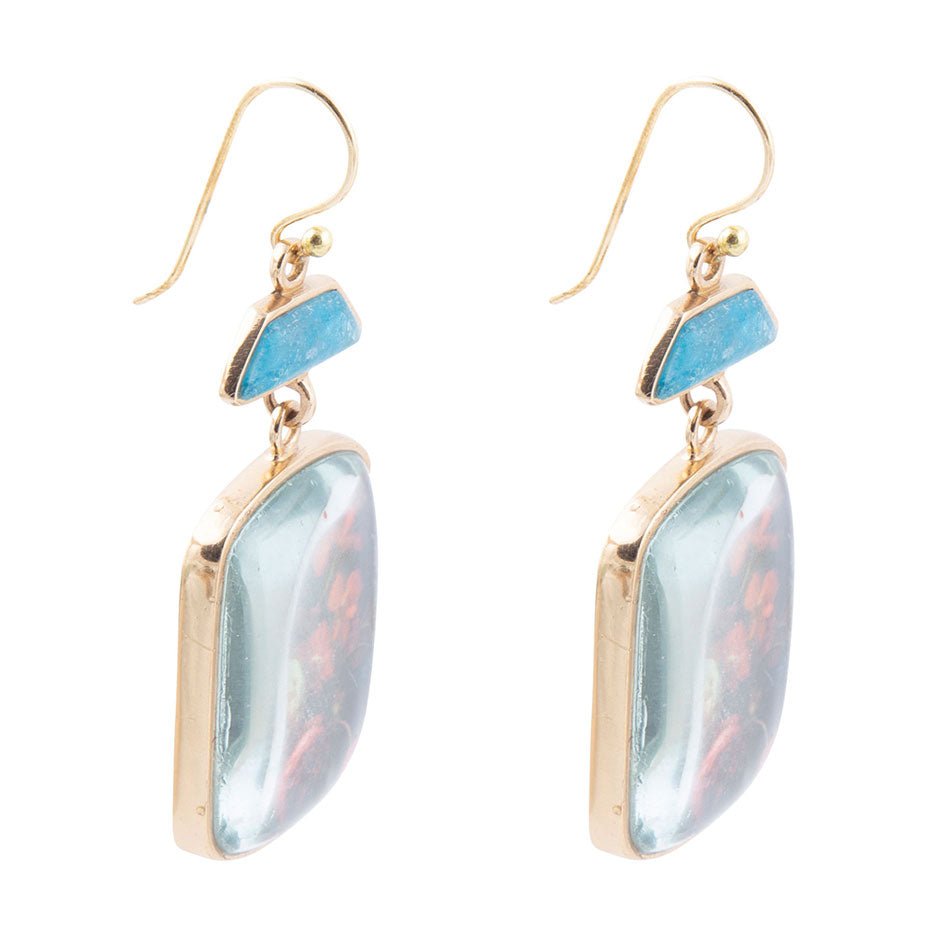 Orecchini a goccia dorati con apatite blu e fiori scuri scenici