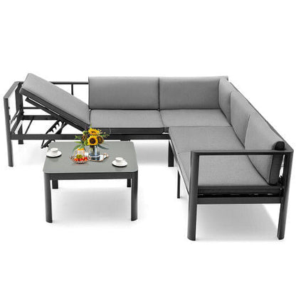 Gray outdoor sectional sofa with a small table and decorative items on a white background