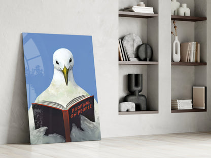 Glazen wanddecoratie met een blauwe lucht, een meeuw en een open boek