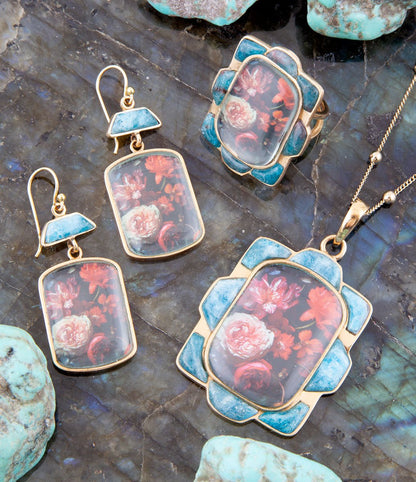 Orecchini a goccia dorati con apatite blu e fiori scuri scenici