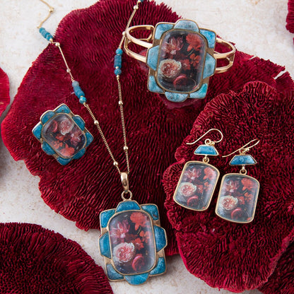 Orecchini a goccia dorati con apatite blu e fiori scuri scenici