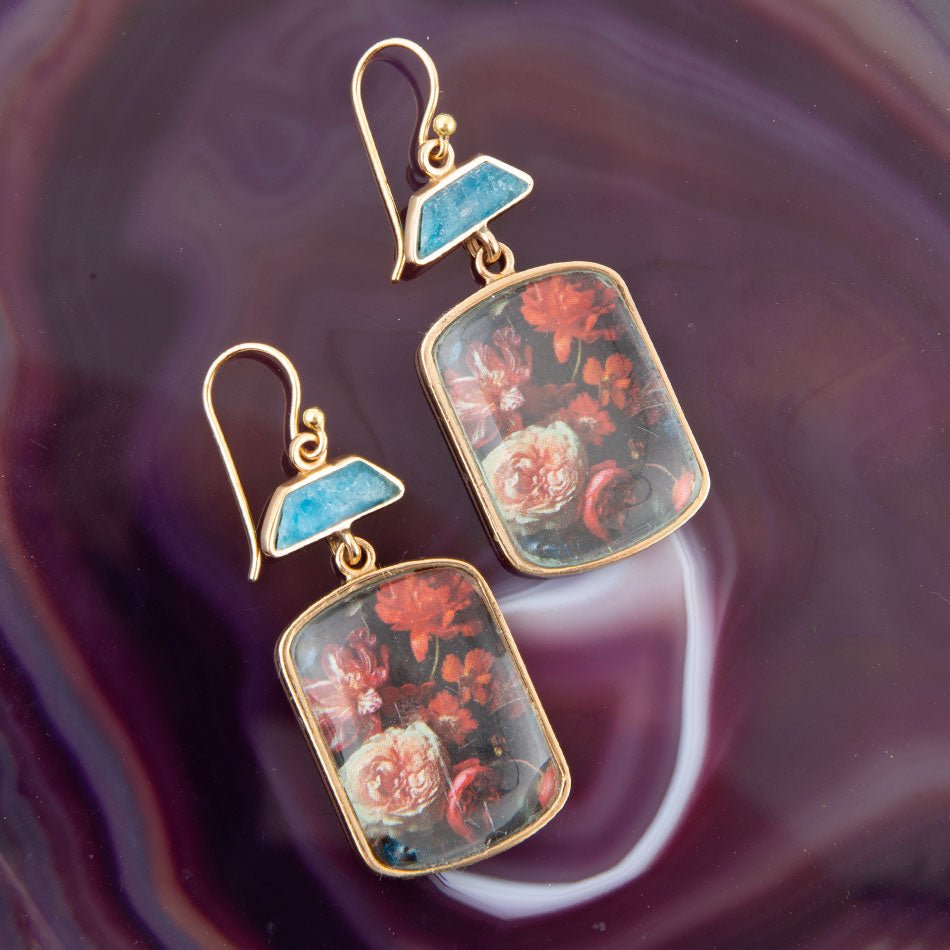 Orecchini a goccia dorati con apatite blu e fiori scuri scenici